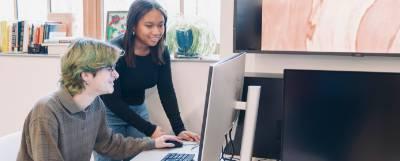 Two people working at a computer.